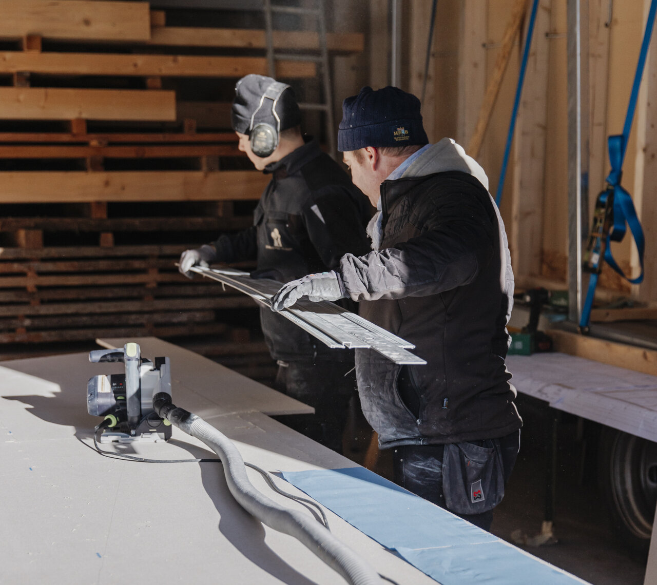 Zwei Mitarbeiter der Zimmerei Huber arbeiten gemeinsam im Werk.