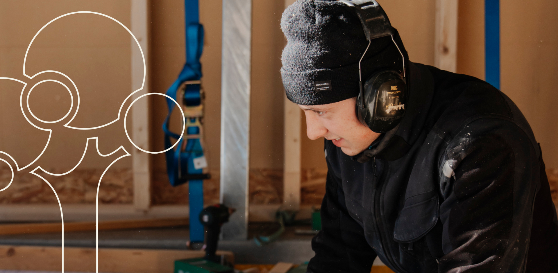 Ein Geselle der Zimmerei Huber mit Lärmschutz und Mütze bei der Arbeit im Werk.